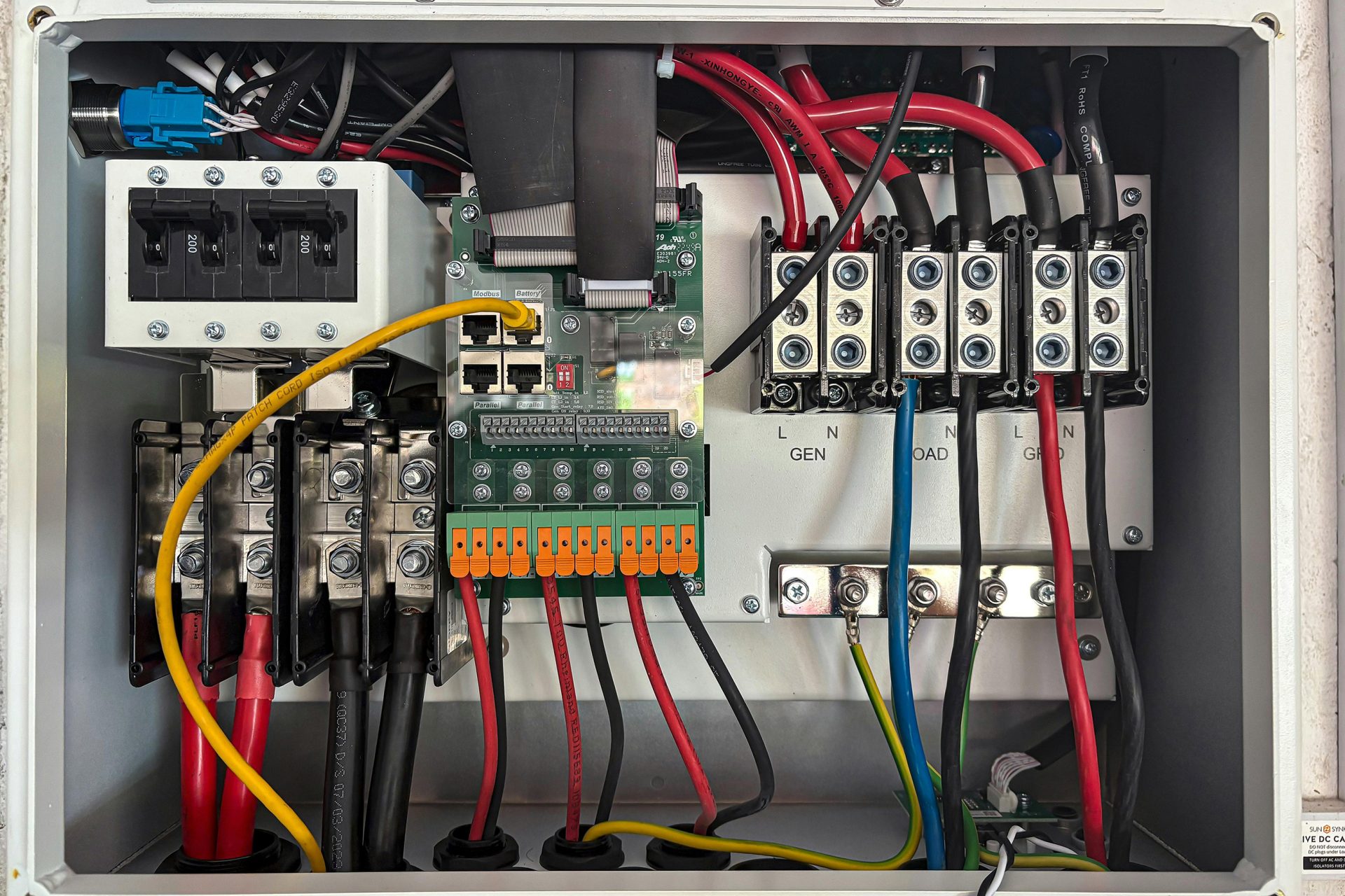 Leistungen im Bereich Elektrotechnik Übersicht des elektrischen Panels mit sichtbaren Kabeln und Geräten zur Stromversorgung.